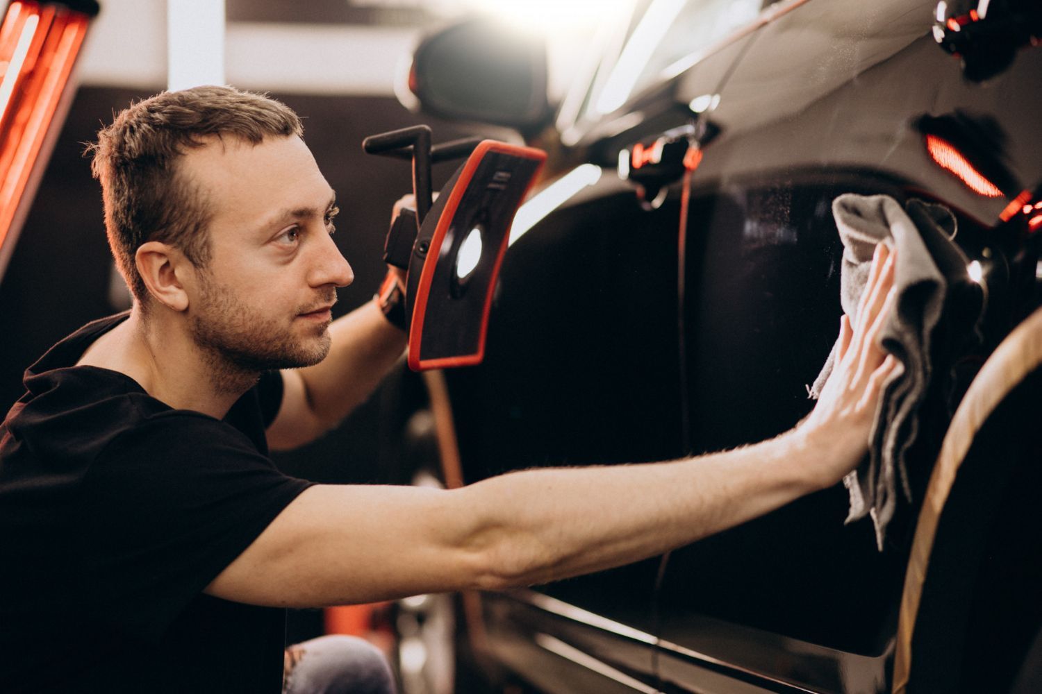 Velocity Auto Group technician detailing a red vehicle